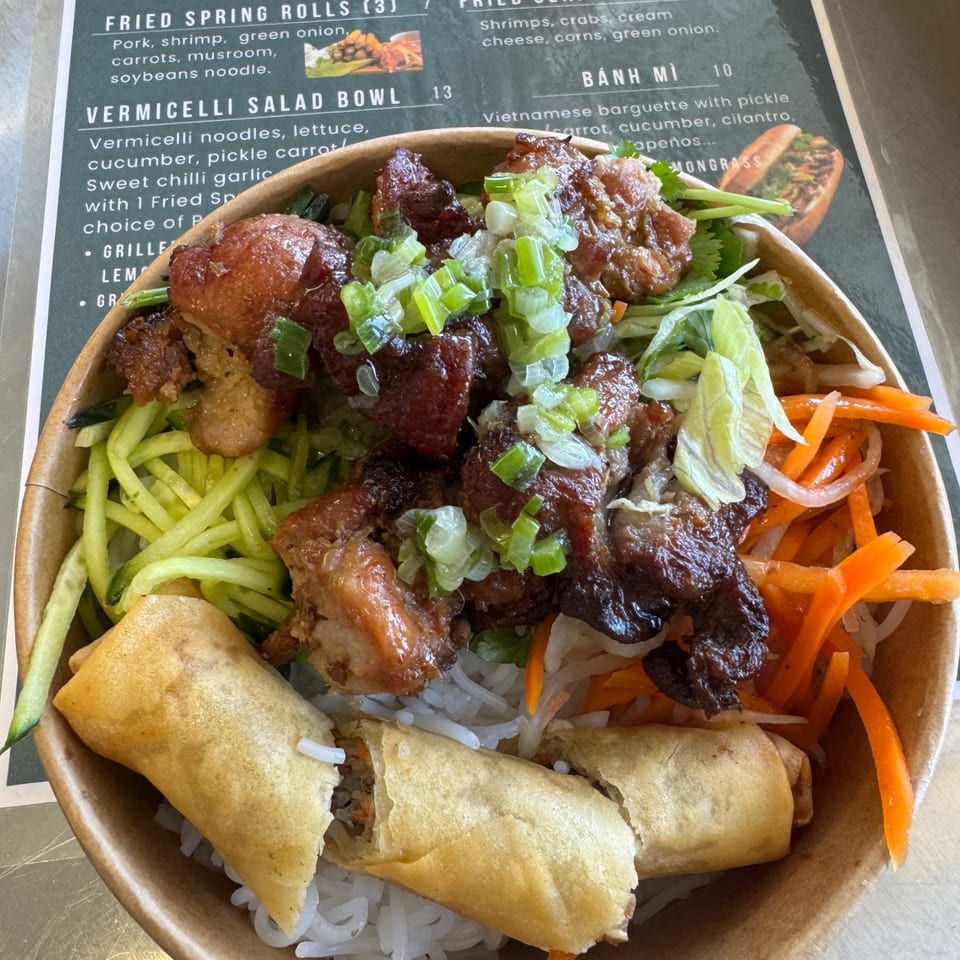 Vermicelli bowl with grilled meat, vegetables and spring rolls